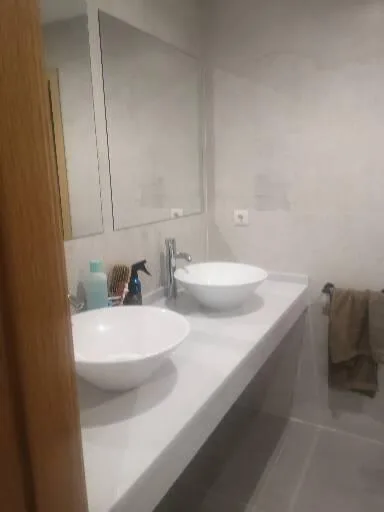 Baño con dos lavabos redondos y grifería cromada